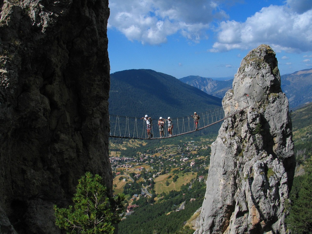 People crossing a rope bridge during their Via Ferrata adventure holiday in France