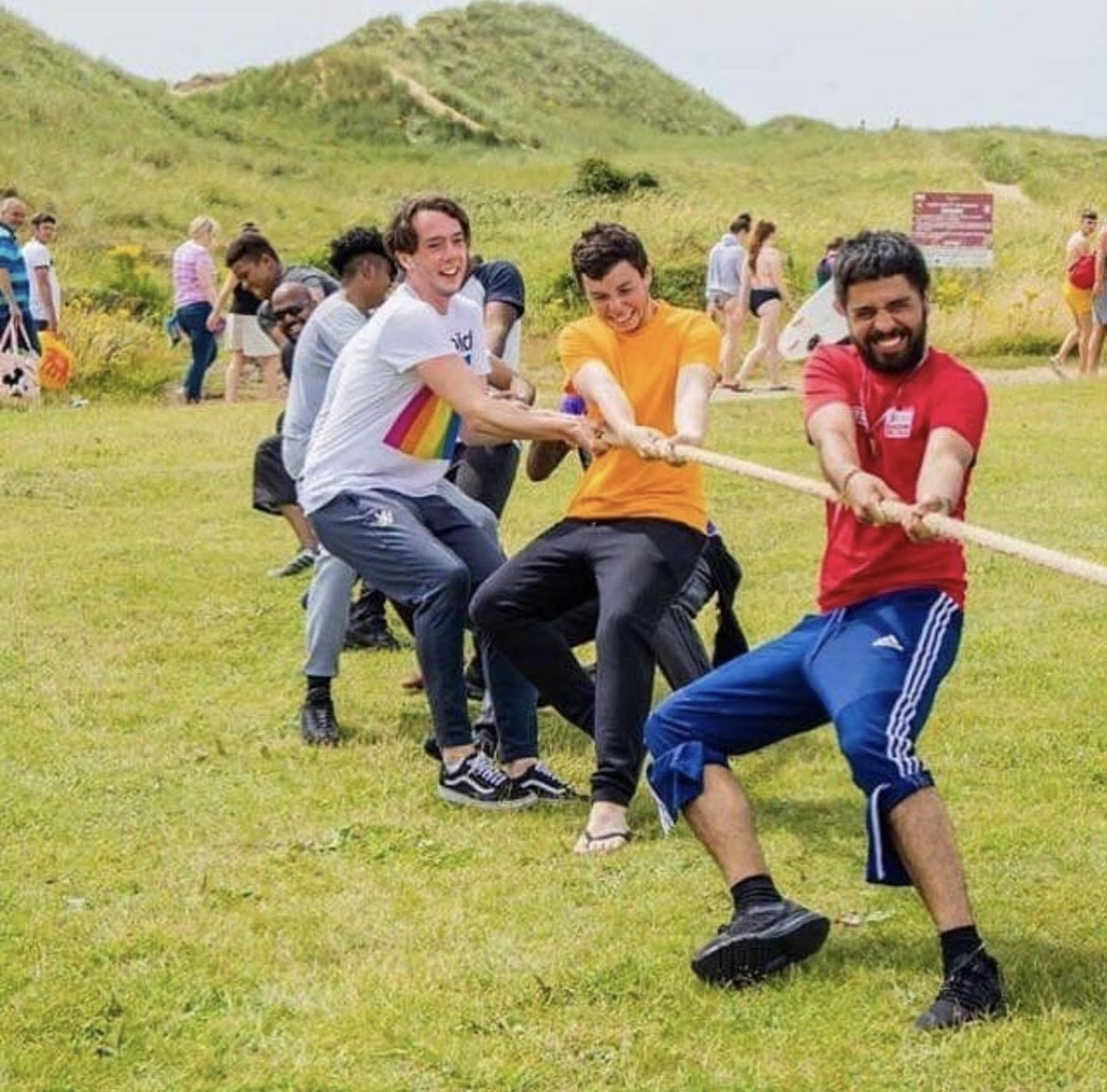 Team of boys pulling the rope during their tug of war youth group activity.