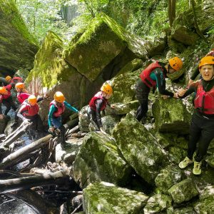 Group of children climbing rocks during their school residential trip in Wales.