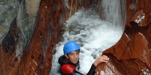 A person on a waterfall while on a canyoning activity holiday in France.