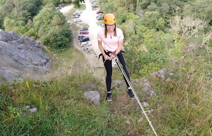 A woman having fun abseiling in Wales